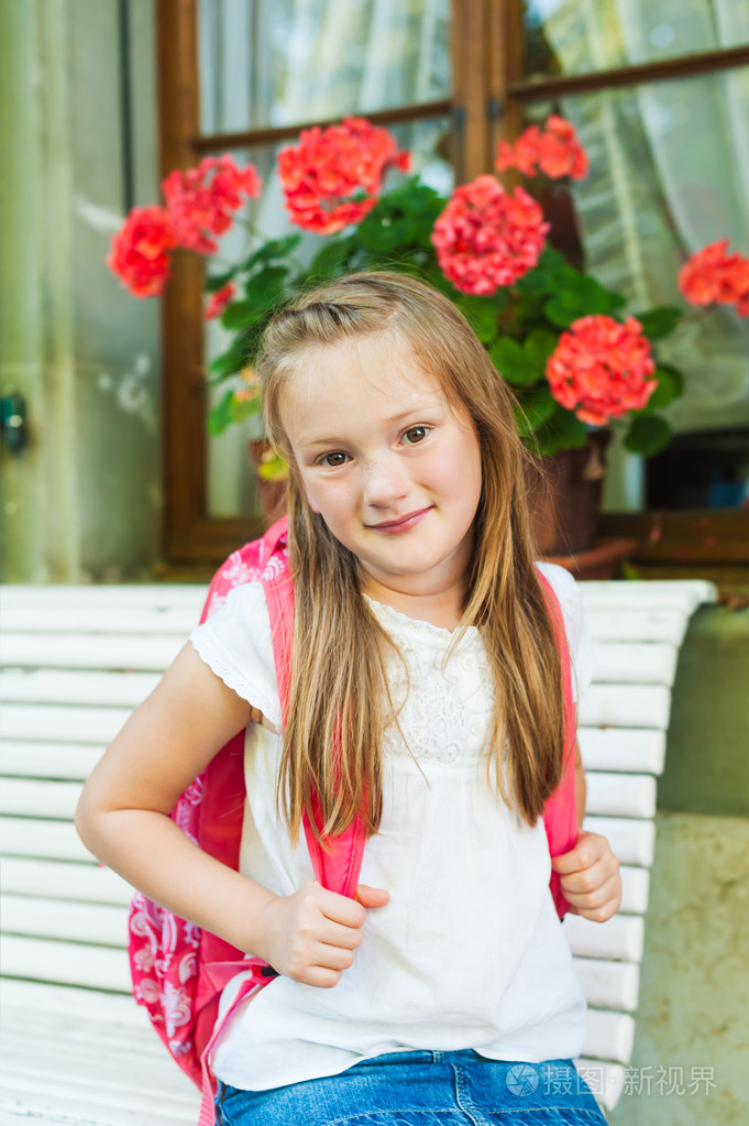 一个可爱的小女孩,放学后在长椅上休息的室外肖像