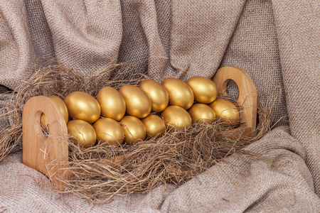干草在木架子上的黄金复活节彩蛋。