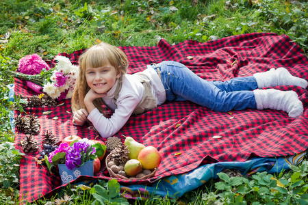 美丽的小小婴儿躺在一个红色的格子.可爱的孩子微笑着鲜艳的花照片