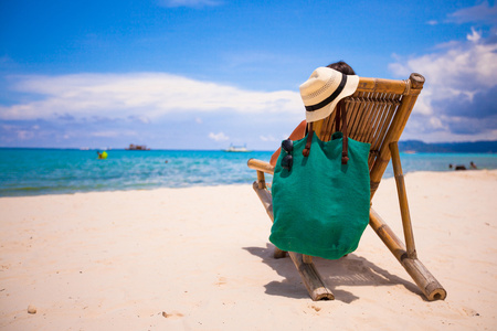 坐在木椅上海滩在暑假期间的年轻人