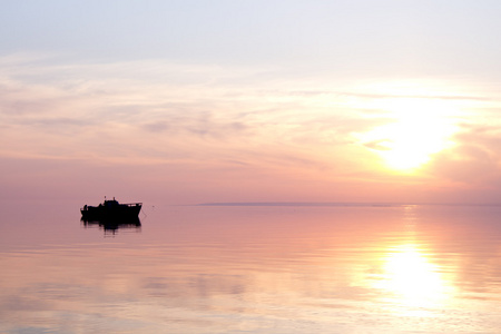 一艘小船在日落时的剪影