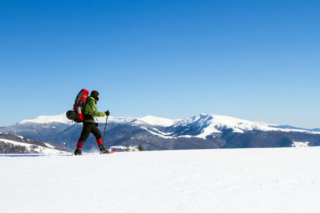 在山里徒步旅行带着背包和帐篷雪的冬天