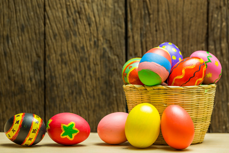 复活节彩蛋在篮子和木材的背景