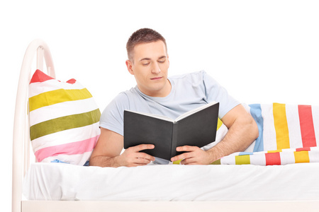 躺在床上的男人阅读本书