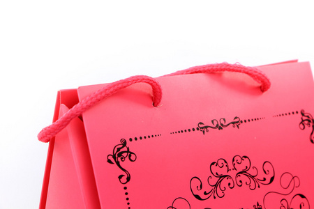 粉红色与白色衬底上分离的旋流设计特写的购物袋