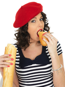 年轻漂亮的女人吃法国棍子面包