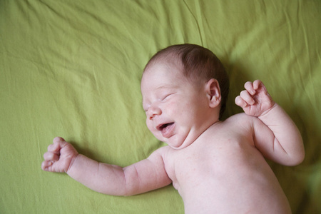 新生儿在绿色床单上哭泣