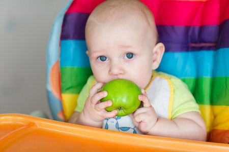 可爱的宝宝吃苹果在高脚椅