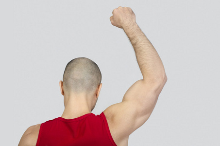 从提高他的手臂和拳头后面的人照片