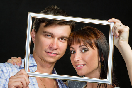 年轻夫妇开心做鬼脸通过框架图片