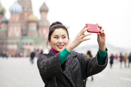 年轻漂亮的女人旅游拍照手机