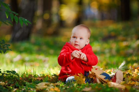 快乐宝贝穿着红色和黄色的叶子一起玩