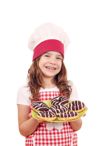 快乐的小女孩用甜甜的巧克力甜甜圈做饭