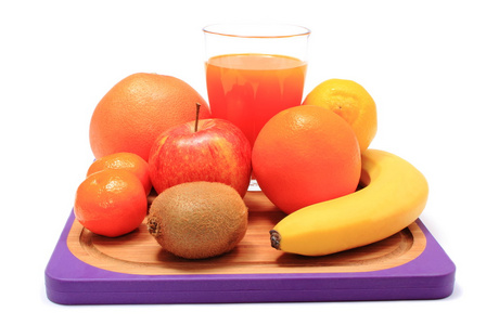 新鲜的天然水果和果汁在砧板上的玻璃