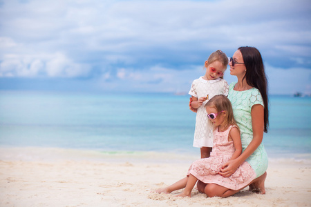 幸福的母亲和两个孩子在异国风情的沙滩上阳光灿烂的日子