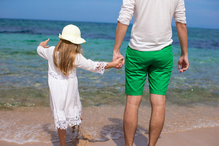 快乐的父亲和他可爱的女儿，在白色的沙滩