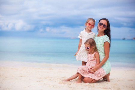 幸福的母亲和两个孩子在异国风情的沙滩上阳光灿烂的日子