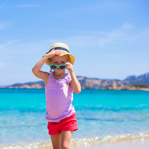 可爱的小女孩在地处热带的海滩假期玩得开心
