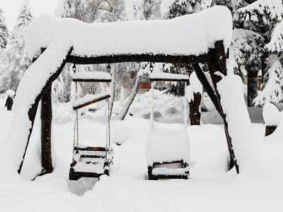 木制儿童秋千被雪覆盖图片