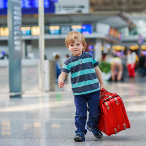 你打算在假期旅行的行李箱在机场的小男孩