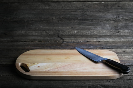 用锋利的水果刀，心疼的 grunge 木制的桌子，在一个乡村厨房 视图与小插图和 copyspace 上的空砧板