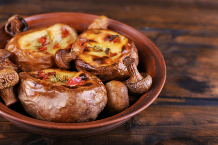 烤的土豆与蘑菇在碗上木制背景