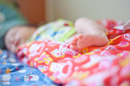 小小的腿刚出生的婴儿在粉红色的纸尿裤