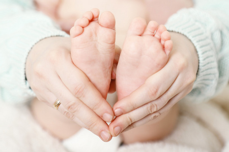 在女性手里，刚出生的婴儿脚特写