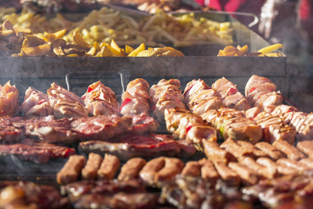 从烤架上烤的肉和香肠配烟和蒸汽不同种