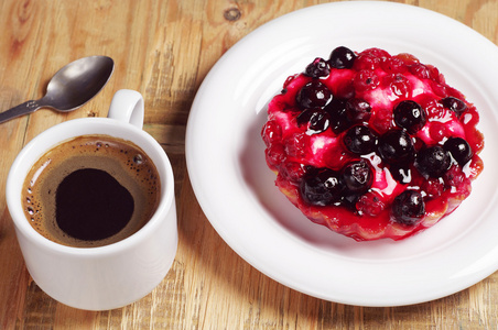 咖啡和美味的蛋糕与黑醋栗照片