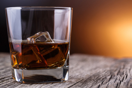 杯威士忌和一张木桌上的冰