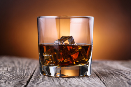 杯威士忌和一张木桌上的冰