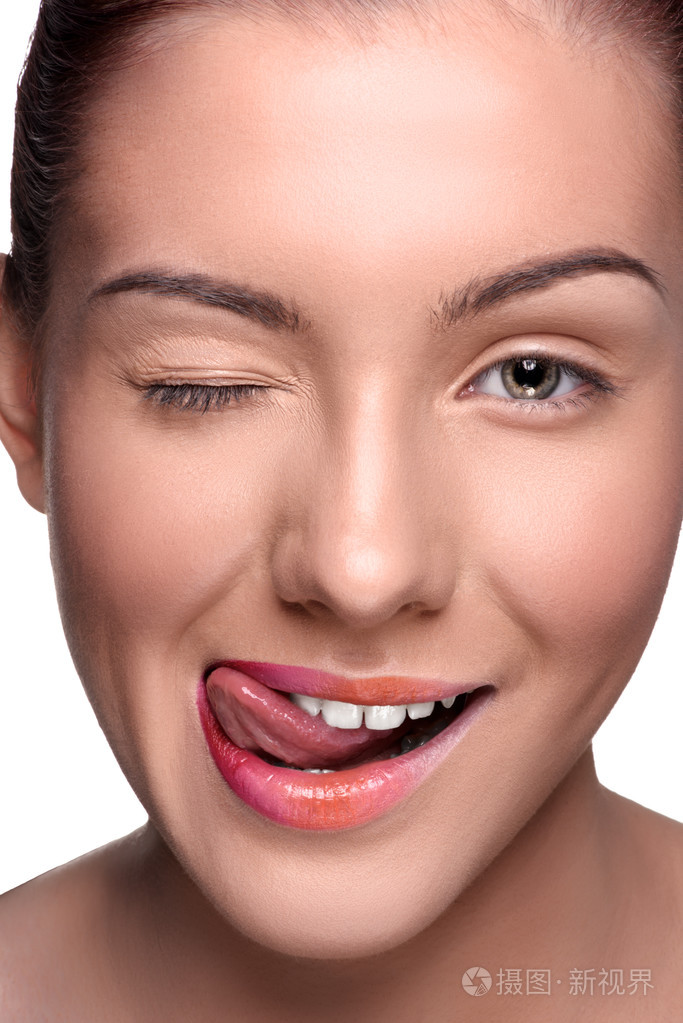 年轻微笑的快乐的女人摆姿势展示她的舌头