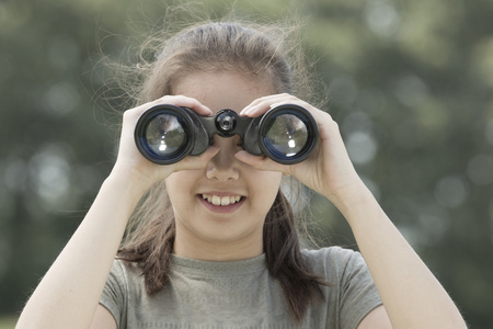 年轻漂亮的女孩，探索环境用双筒望远镜