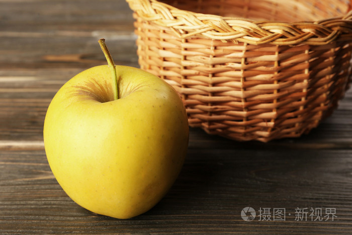 苹果与柳条篮子上木制背景