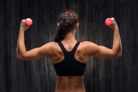 混血的种族与哑铃运动女人的背影健康强壮的年轻人的背影一个运动的
