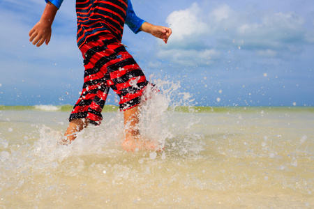 在夏天的海滩上玩水的小男孩