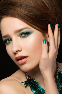 华丽的年轻女子，与蓝色的指甲和眼部化妆的肖像