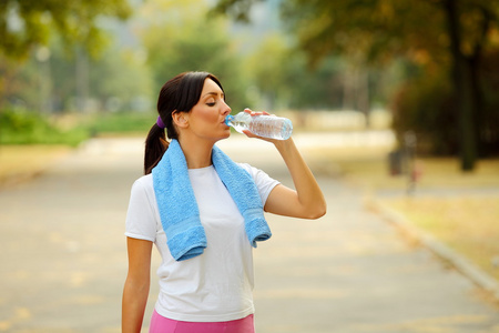 健身后的运动型女人喝水