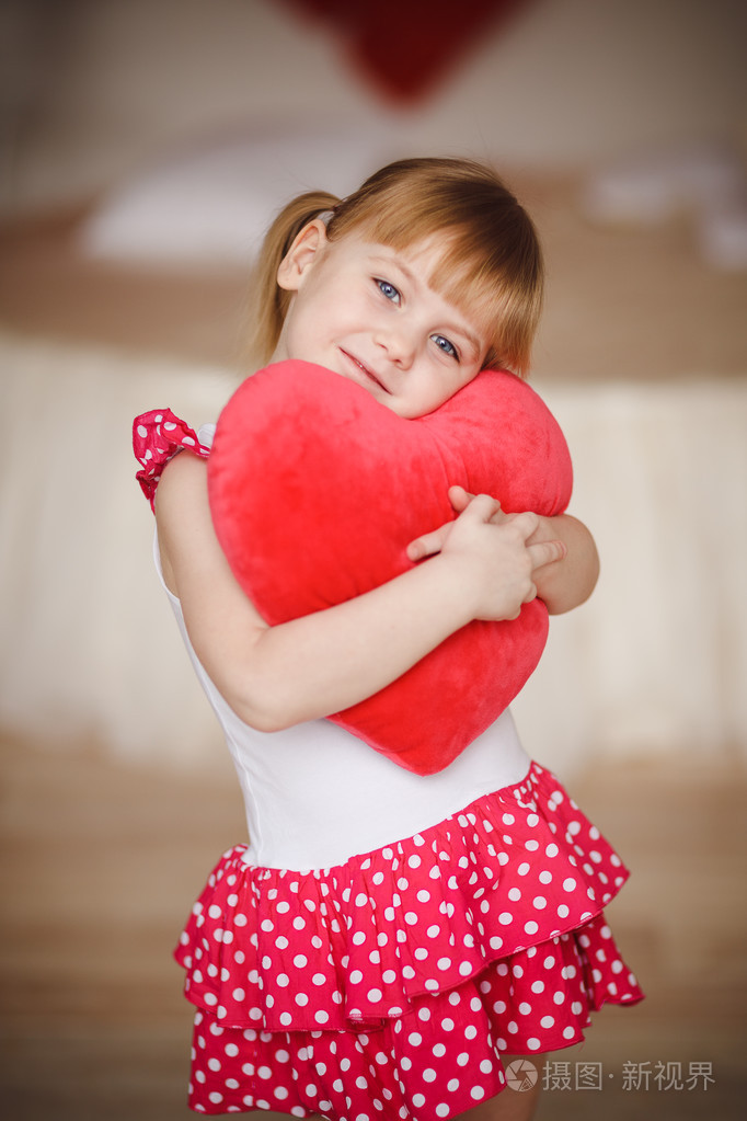 小女孩抱着的心形枕头.情人节那天.母亲