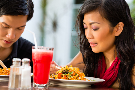 亚洲男人和女人在餐厅吃东西