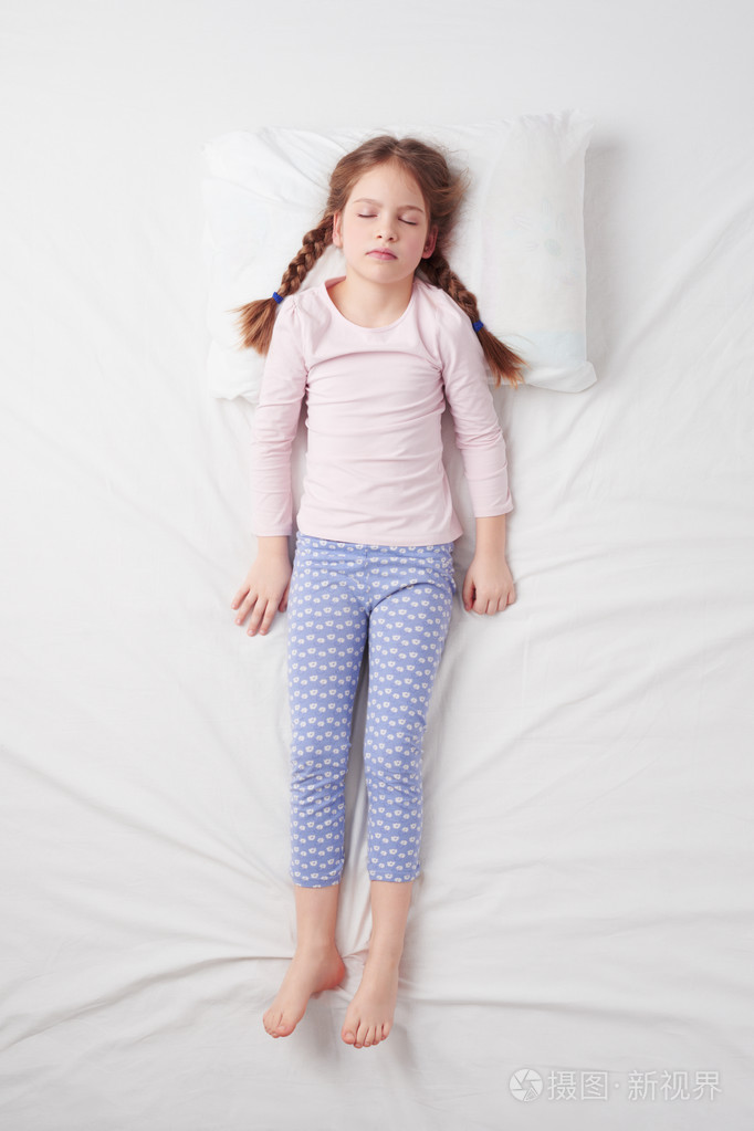 顶视图的可爱的小女孩睡在士兵的姿势