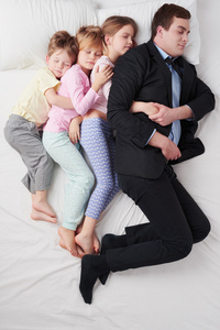 孩子们睡在一起的父亲的顶视图