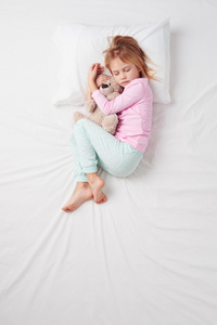 顶视图的小女孩睡在一起的泰迪熊