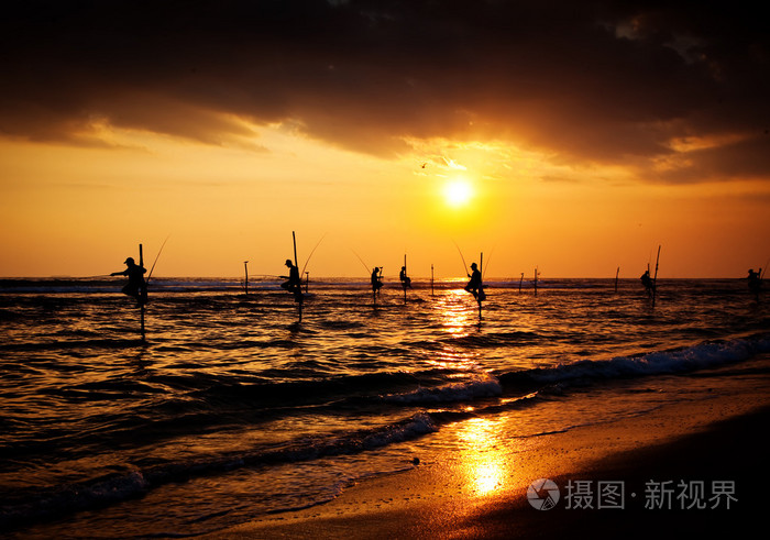 传统的高跷渔民在日落 nea 的剪影