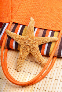 沙滩袋用毛巾和木制的背景上的海星