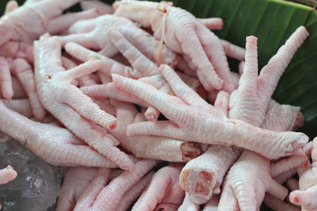 在市场的新鲜鸡脚鸡脚绘图舂米, 碗, 香菜和辣椒在黄色背景上中国食品