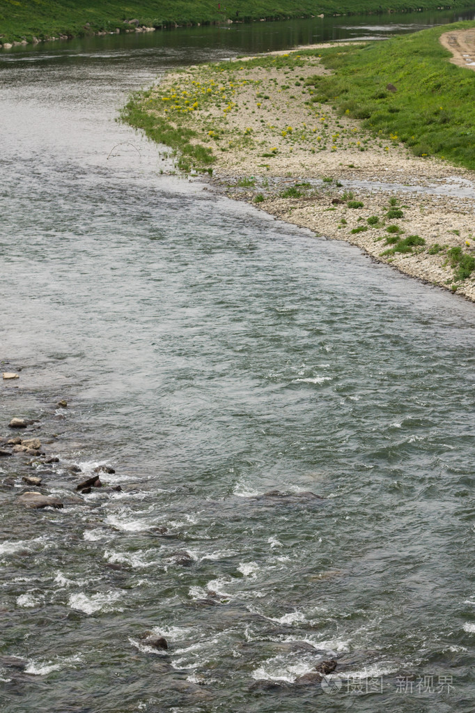 城镇河流流动和河岸上的绿草