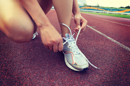 女子赛跑运动员绑鞋带