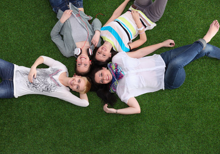 四名年轻女子躺在绿色的草地上